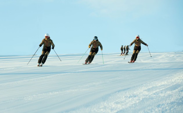 Mehrere Personen fahren auf einer schneebedeckten Piste Ski